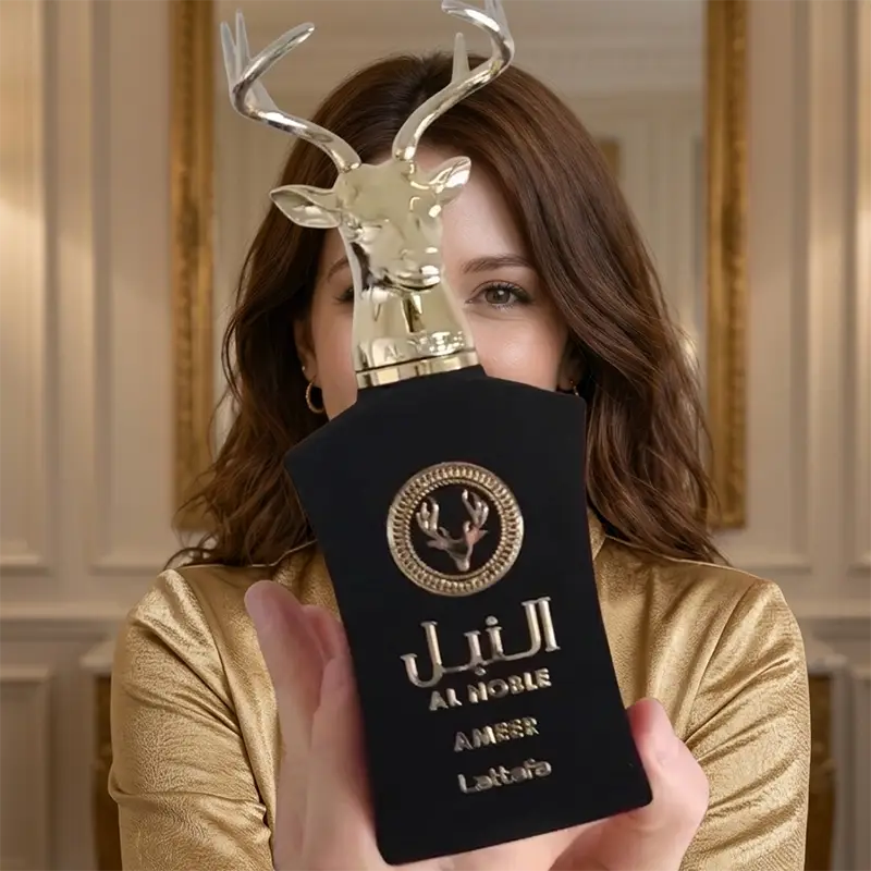 Elegant lifestyle presentation of the Lattafa Al Noble Ameer bottle held by a model.