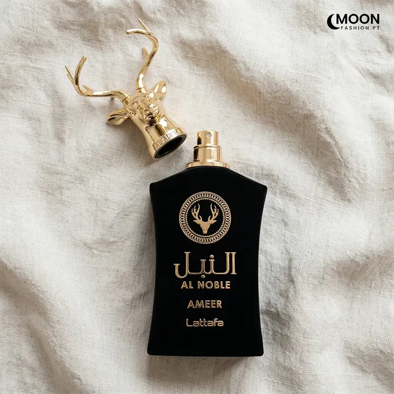 Overhead view of the Lattafa Al Noble Ameer spray nozzle and the golden stag head cap on a linen background.
